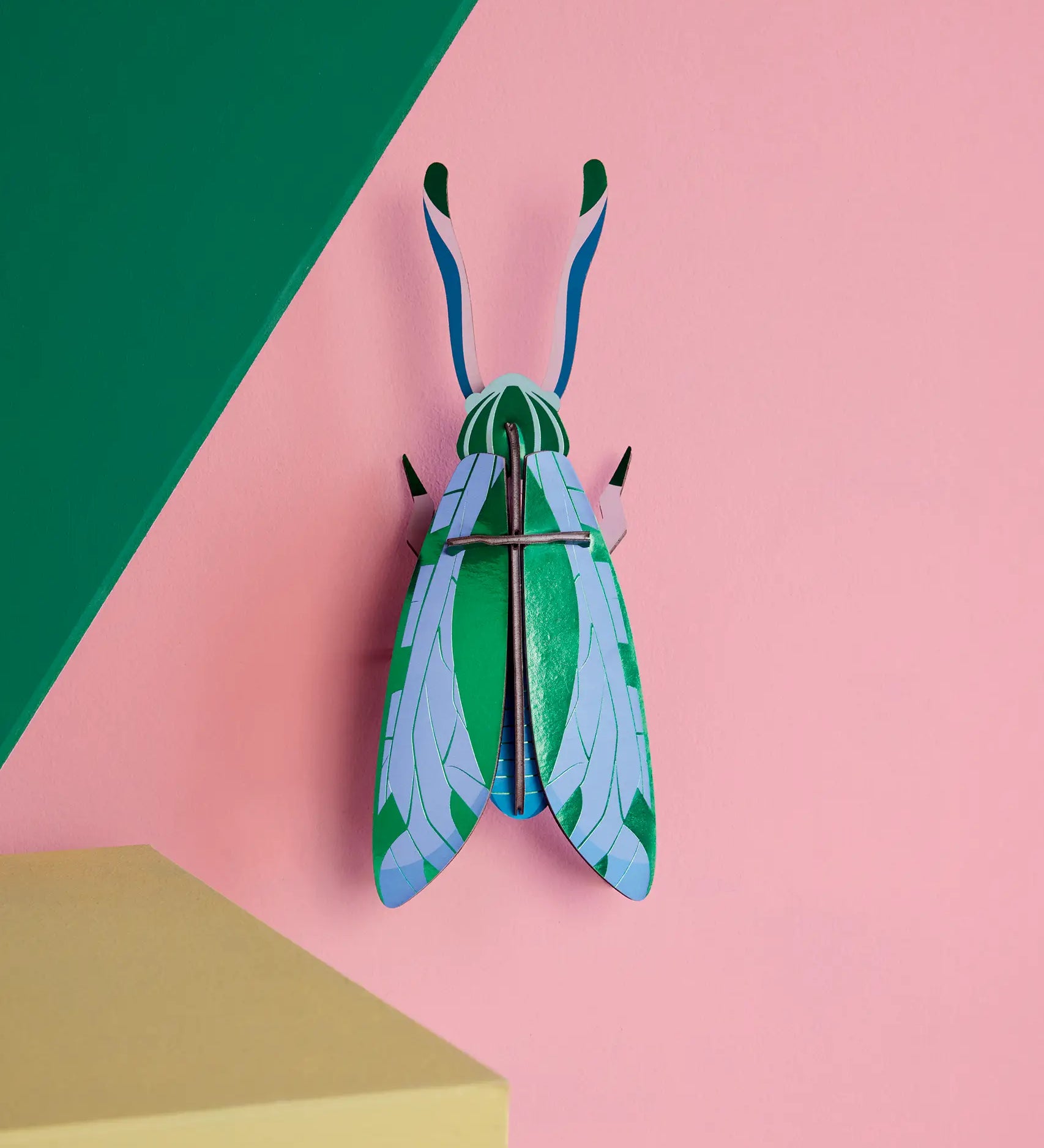 Studio Roof 3D cardboard jade grasshopper craft kit displayed on a wall 