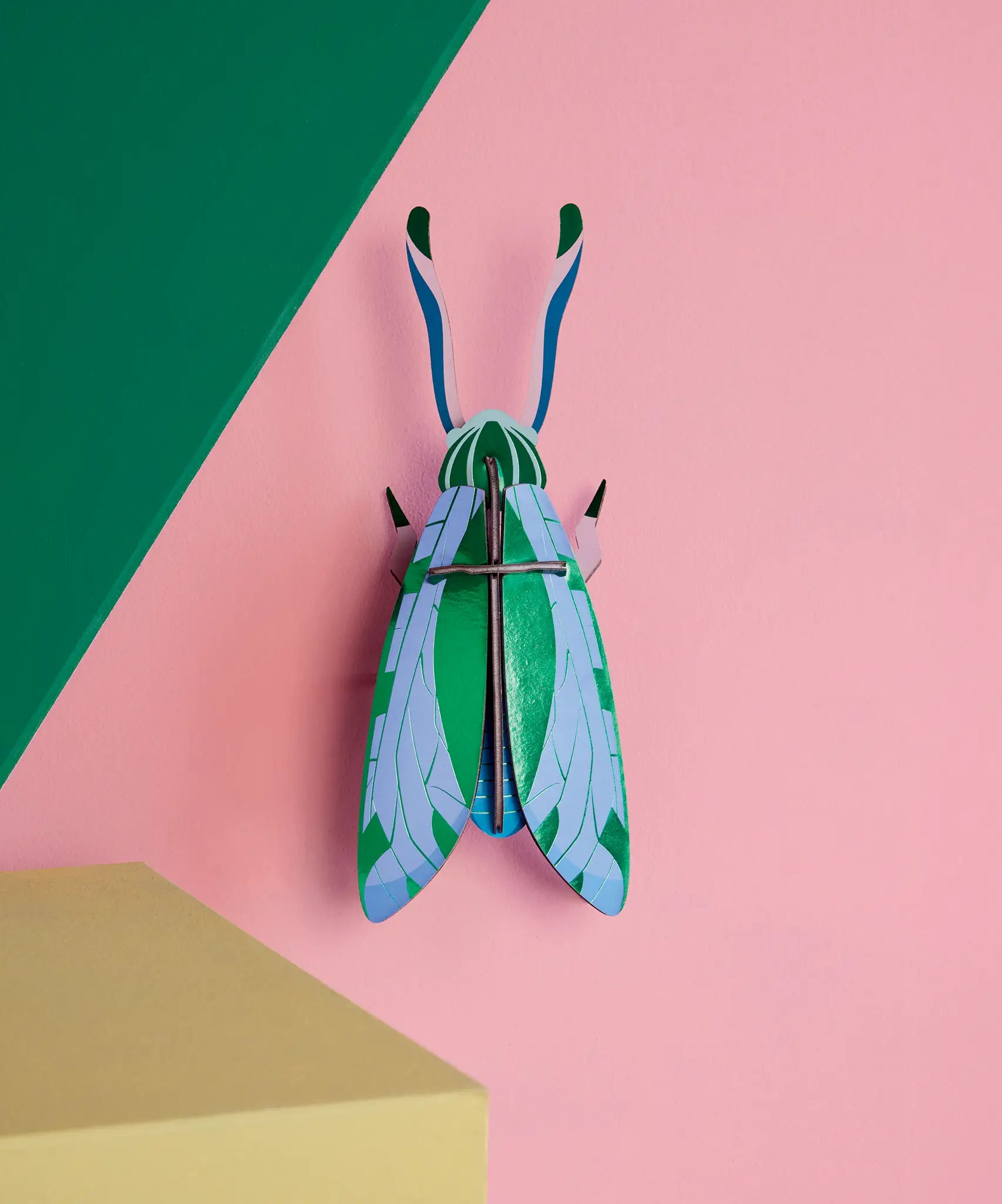 Studio Roof 3D cardboard jade grasshopper craft kit displayed on a wall 