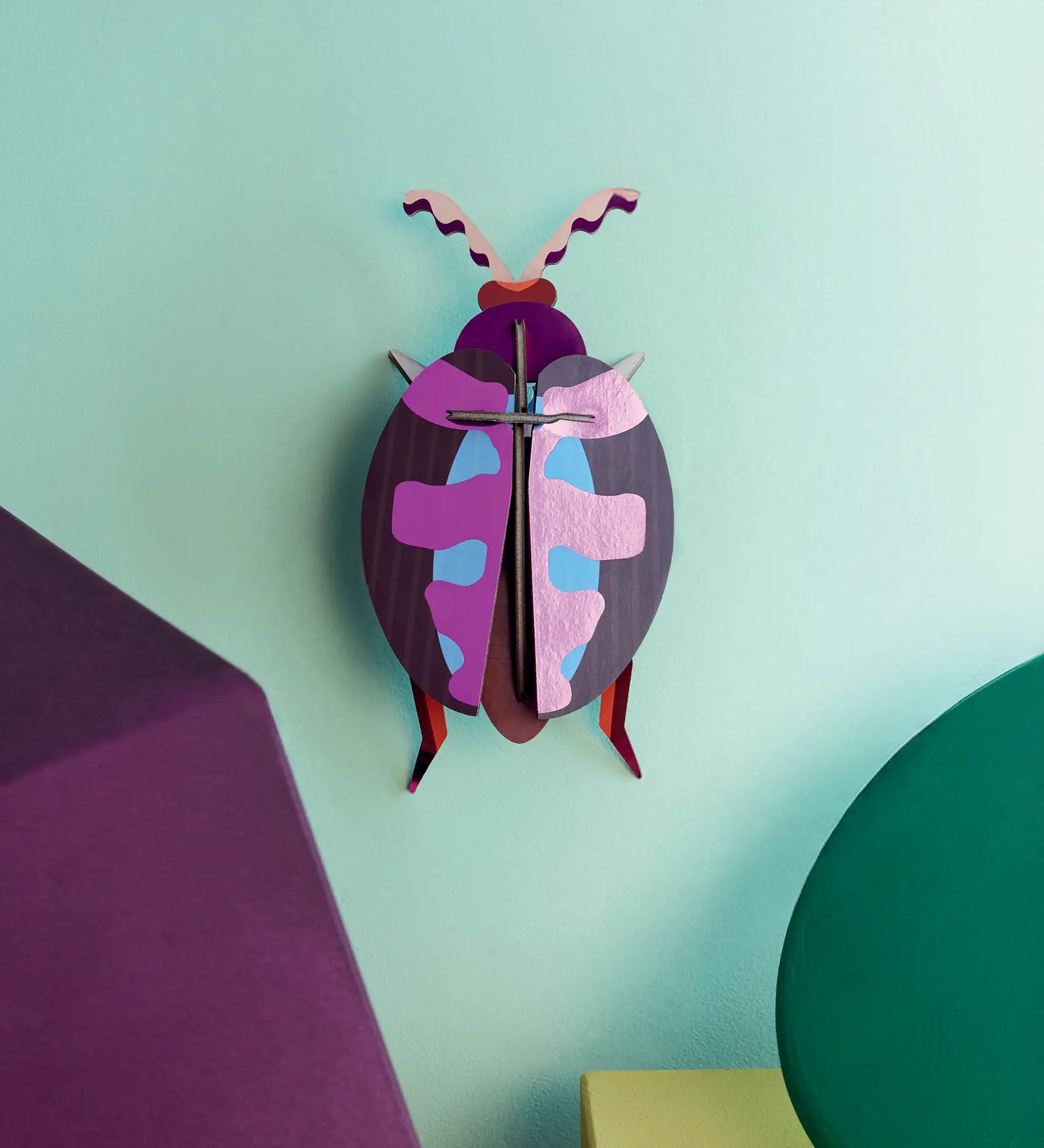 Studio Roof 3D cardboard lumen pink beetle craft kit displayed on a wall 