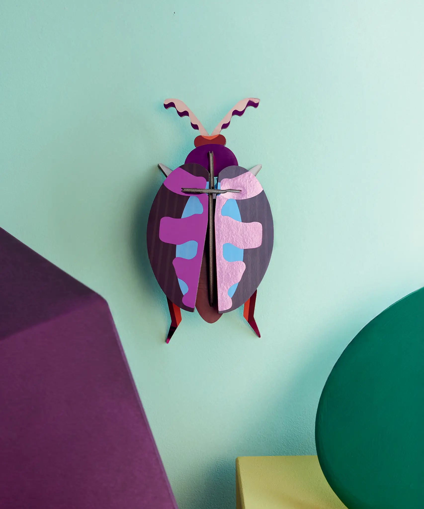Studio Roof 3D cardboard lumen pink beetle craft kit displayed on a wall 