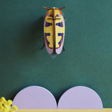 Studio Roof Mango Flower Beetle hung up on a dark green coloured wall