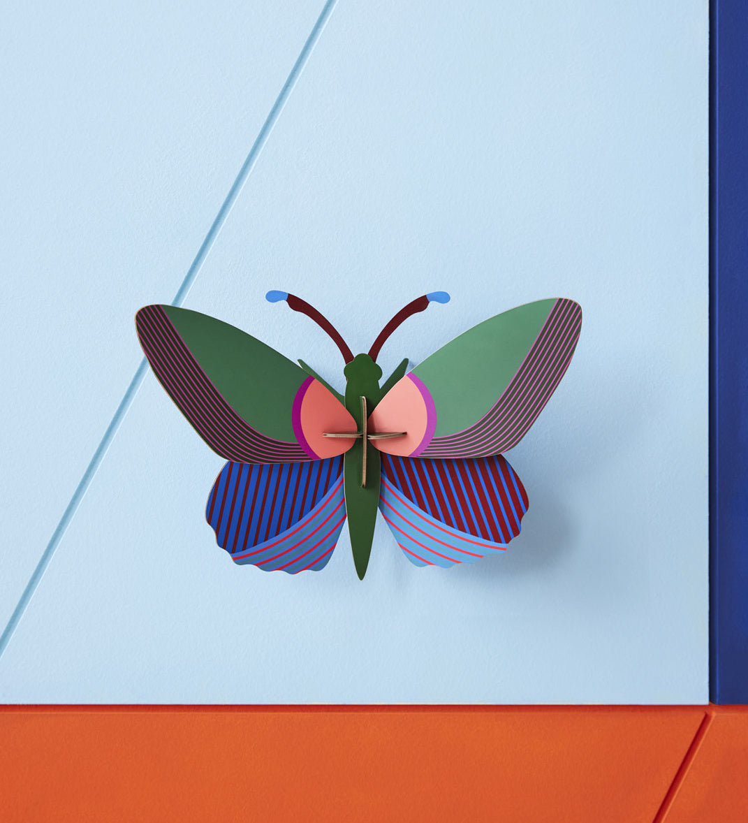 Studio Roof Medium Acacia Butterfly pictured on a blue wall