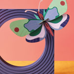 Studio roof slotting cardboard mint forest butterfly model climbing on a purple block sculpture in front of a pink wall