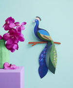 A Studio Roof 3D paradise peacock bird perched on a branch displayed on a wall