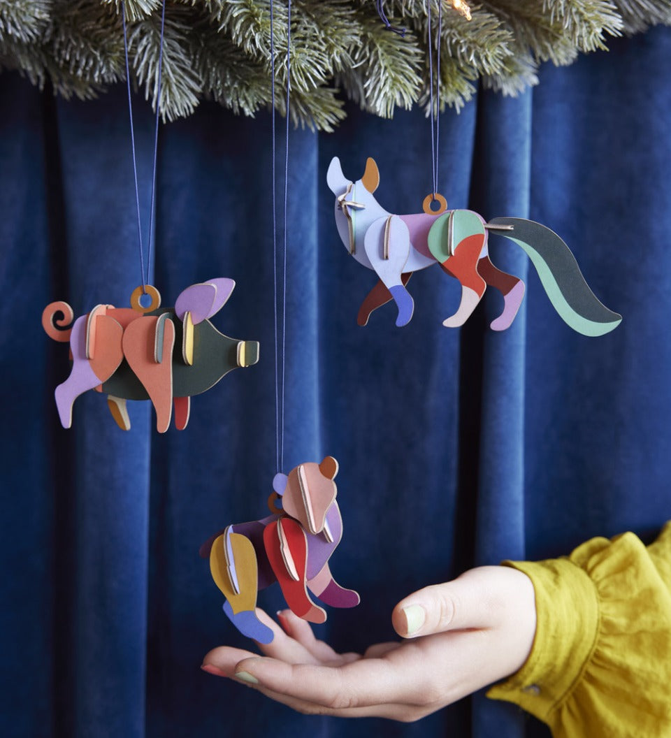 Close up of a hang reaching out to touch a Studio Roof plastic-free animal hanging decoration