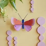 Studio Roof Speckled Copper Butterfly decoration on a pastel yellow coloured painted wall