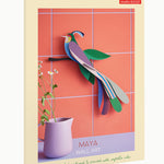 Studio Roof Maya bird of Paradise sat on a dark brown tree branch with green leaves