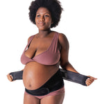 A person showing how to put on the Lola & Lykke Core Relief Pregnancy Support Belt