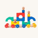 Tegu Big Top Magnetic Tram toy pictured on a plain background. The blocks have been stacked on top of each other with one of the  wooden dollies placed on top. 