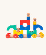 Tegu Big Top Magnetic Tram toy pictured on a plain background. The blocks have been stacked on top of each other with one of the  wooden dollies placed on top. 