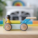 Tegu wheels made into a vehicle with other magnetic wooden pieces and a Clique figure on top