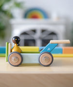 Tegu wheels made into a vehicle with other magnetic wooden pieces and a Clique figure on top