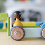 A close up of the Tegu wheels made into a vehicle with other magnetic pieces and a Clique figure on top