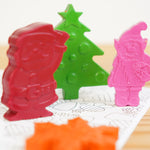 The crayon bug festive crayon pack stood up on a colouring book