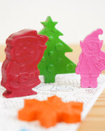 The crayon bug festive crayon pack stood up on a colouring book