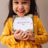 Child holding a box of The Phive Enchanting Learning Phonics & Storytelling Cards - Set 1