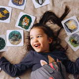 Child lying down surrounded by cards from the The Phive Enchanting Learning Phonics & Storytelling Cards  Set 2