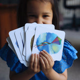 Child holding the cards from the The Phive Enchanting Learning Phonics & Storytelling Cards - Set 3 in a fan front of their face