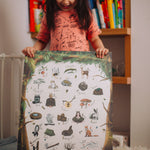 A child holding up the The Phive Enchanting Woodland Alphabet Print