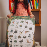 A child holding up the The Phive Enchanting Woodland Alphabet Print