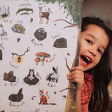 A close up of a child holding The Phive Enchanting Woodland Alphabet Print