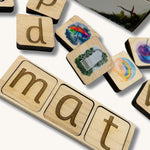 A close of the lettered phonic tiles with pictured phonic tiles scattered around