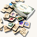 Phonic tiles with letters and pictures scattered around the cardboard storage box.