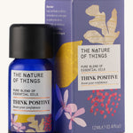 Think Positive pure essential oil blend in a blue glass bottle in front of a decorative purple cardboard box.