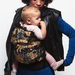 An adult carrying a baby in the Love Radius PhysioCarrier in Tiger.