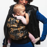 An adult carrying a baby in the Love Radius PhysioCarrier in Tiger.
