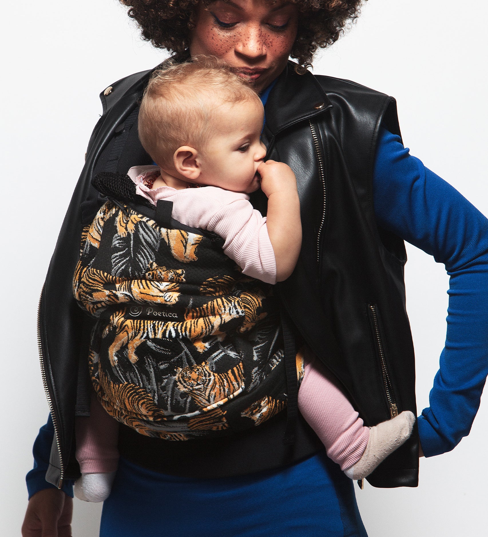 An adult carrying a baby in the Love Radius PhysioCarrier in Tiger.