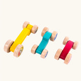 Tobe 3ple Stacking Cars wooden toys. Pink, blue and yellow coloured toy cars. View from above.
