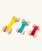 Tobe 3ple Stacking Cars wooden toys. Pink, blue and yellow coloured toy cars. View from above.