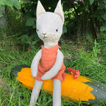 Close up of the Tobe hempions fox toy in a small tree surrounded by red berries