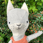Close up of the Tobe hempions fox toy in a small tree surrounded by red berries