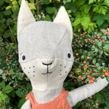 Close up of the Tobe hempions fox toy in a small tree surrounded by red berries
