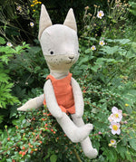 Tobe the hempions fox toy placed on greenery outdoors. 