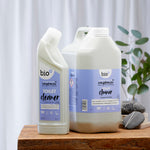  Bio-D 750ml natural toilet cleaner and 5 Litre tub on a wooden table and white background