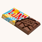 Tony's Chocolonely Rice Crispy Caramel Milk Chocolate Bar shown in it's paper packaging with the paper torn revealing the chocolate bar inside.. 