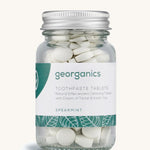 A jar of the Georganics spearmint toothpaste tablets on a cream background