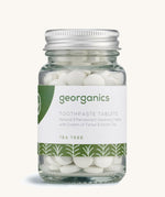A jar of the Georganics tea tree toothpaste tablets on a cream background.