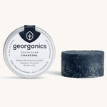 A tin of the Georganics charcoal toothsoap with the tooth soap next to it