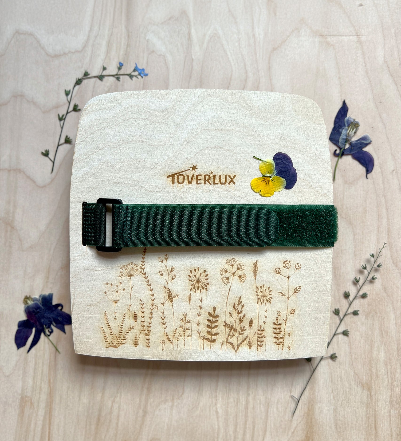 The Toverlux Wooden Flower Press, with dried pressed flowers surrounding the press, on a wooden background