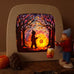 Toverlux DIY kit creation featuring a multicoloured sky with a silhouette of a child carrying a lantern through a forest in a parade displayed in a lit up magic lamp.
