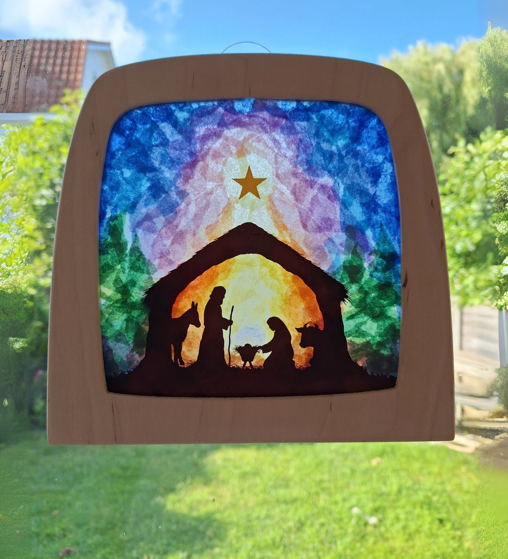 A Toverlux DIY Transparencies with  Winter nativity artwork shown in a wooden magic window frame.