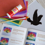Contents of the Toverlux Spring dove DIY silhouette transparency craft kit featuring a Vogel Geluk design. The kit includes silhouette panel with dove design, 20 sheets of coloured paper, paint brush, mod podge glue sealer and a step by step instruction guide.
