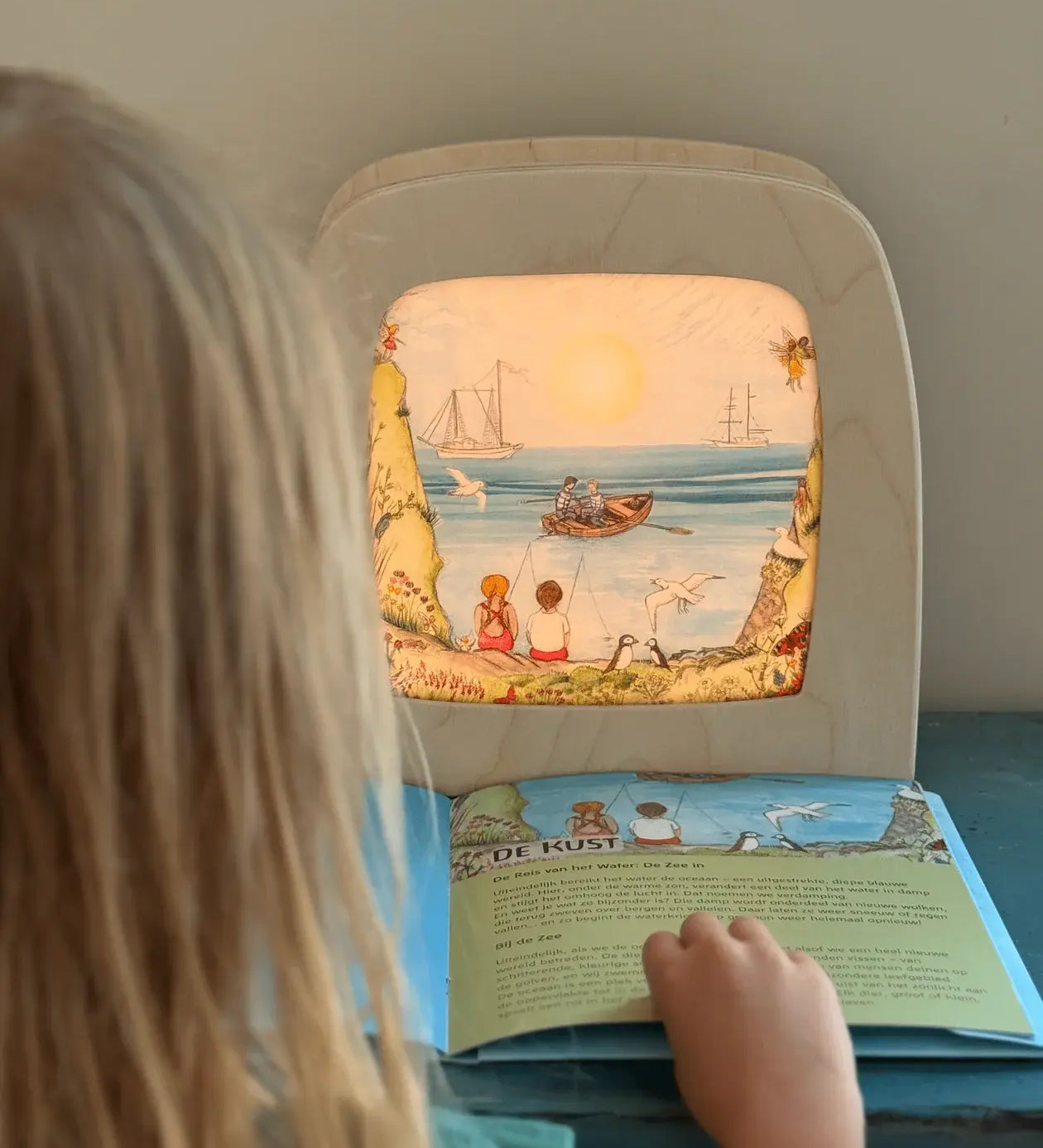 Child looking at Toverlux Edulux Water Cycles Set in the Toverlux Magic Lamp with information book by Stephanie Green Wilded Family.