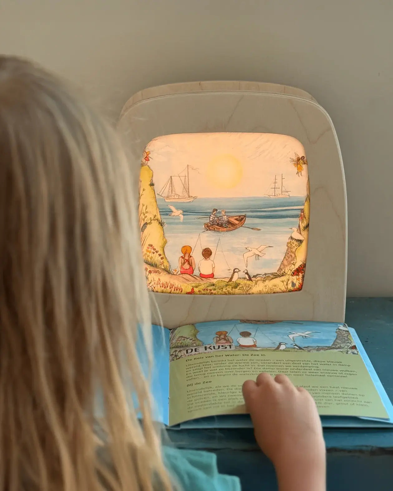 Child looking at Toverlux Edulux Water Cycles Set in the Toverlux Magic Lamp with information book by Stephanie Green Wilded Family.