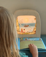 Child looking at Toverlux Edulux Water Cycles Set in the Toverlux Magic Lamp with information book by Stephanie Green Wilded Family.