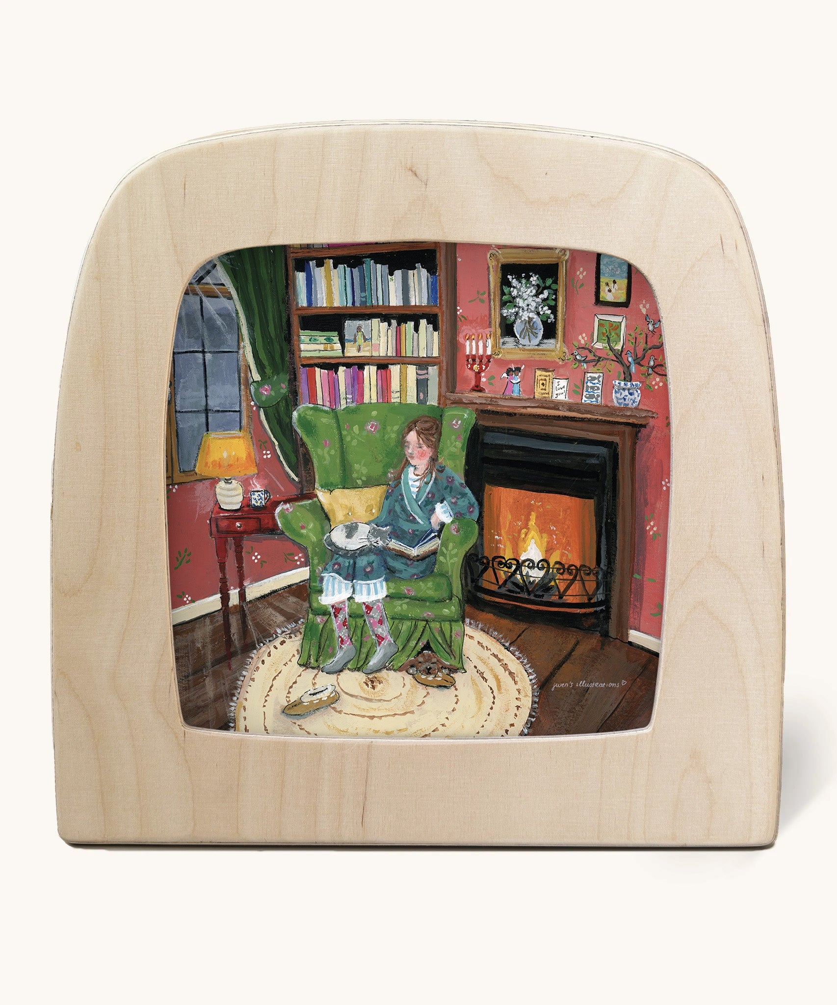Toverlux Magic Lamp silhouette by artist Gwen van Knippenberg. A watercolour and pencil style illustration of a woman ready on a cosy looking green sofa in front of a fireplace, with a grey and white cat sleeping on her lap.